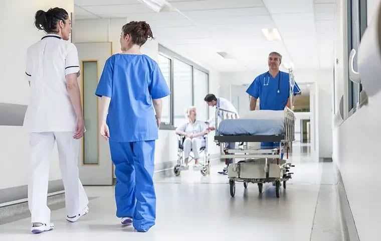 Interior of a hospital corridor with nurses and doctors working