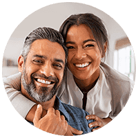 Mature hispanic couple hugging and smiling at the camera